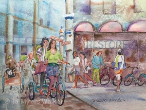 Watercolor painting by artist Jo Myers-Walker with two women bicycling through a downtown Des Moines area neighborhood featuring the word "Restore" on a storefront