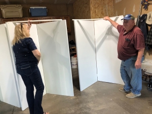 Jeanette and Steve set up a system of hinged panels to display the artwork of Jeanette Carson and Jo Myers-Walker at Reiman Gardens 2023 Garden Art Fair